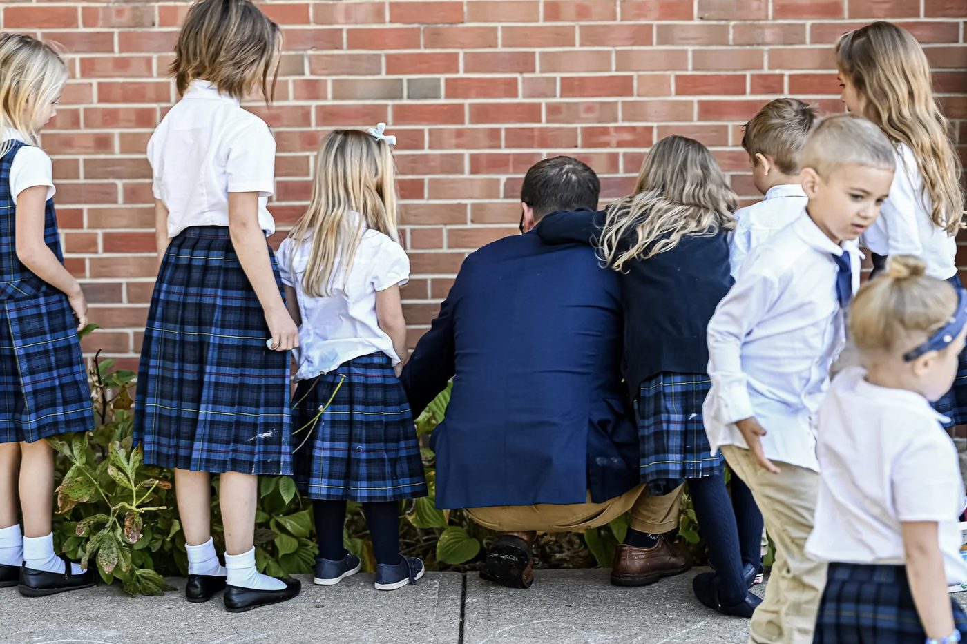Students in uniform gathered around a teacher outside St. Giles Christian Academy